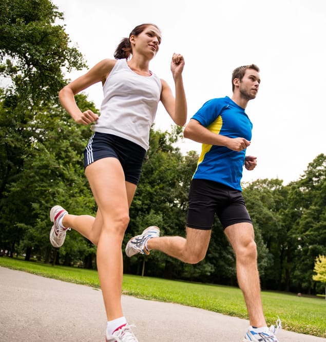 Two people jogging on park path